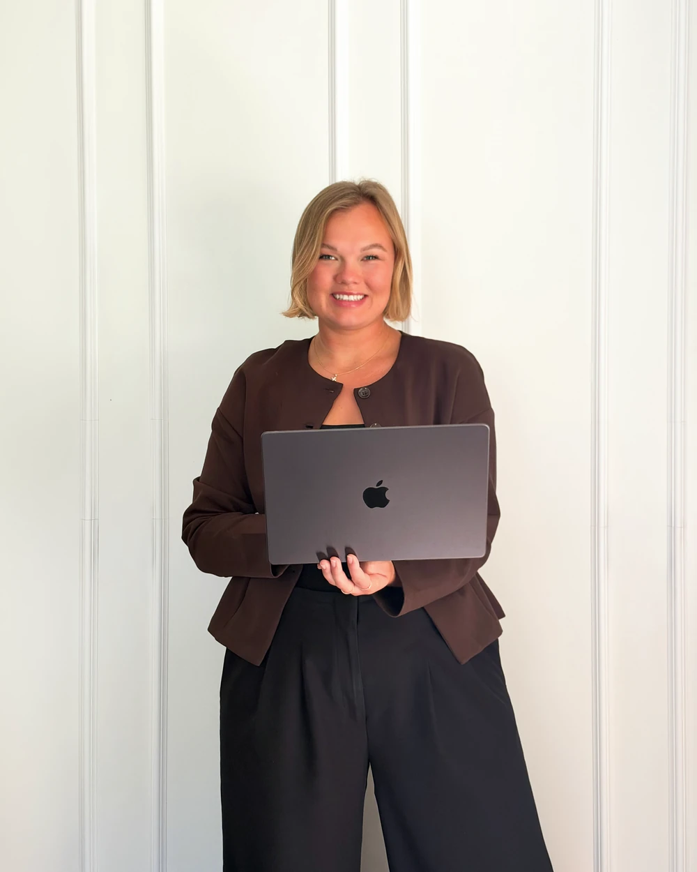 Jessica, founder of Alabaster Bookkeeping, holding a laptop.